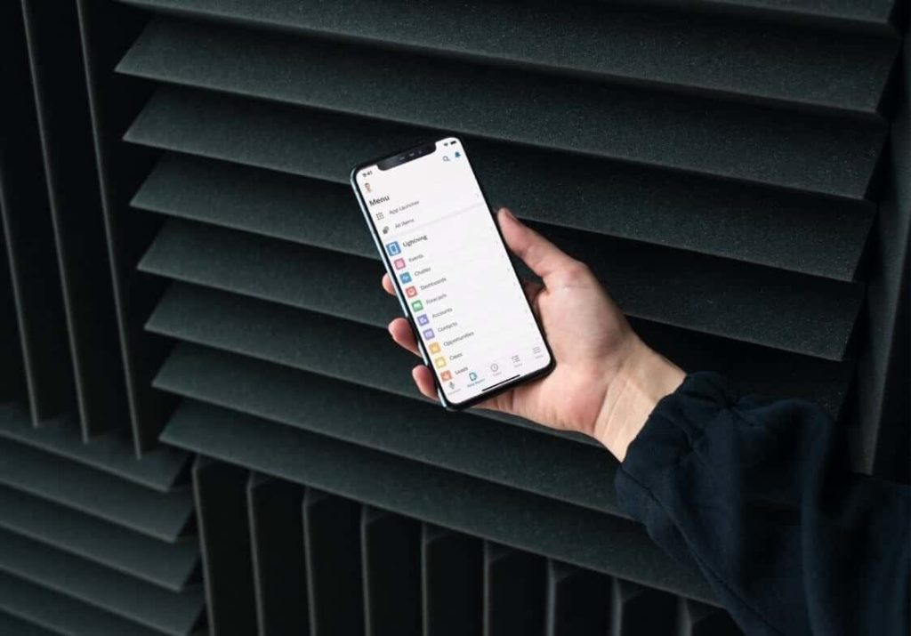 Die Person, die das Smartphone hält, auf dem sie die mobile Version des CRM-Systems verwendet