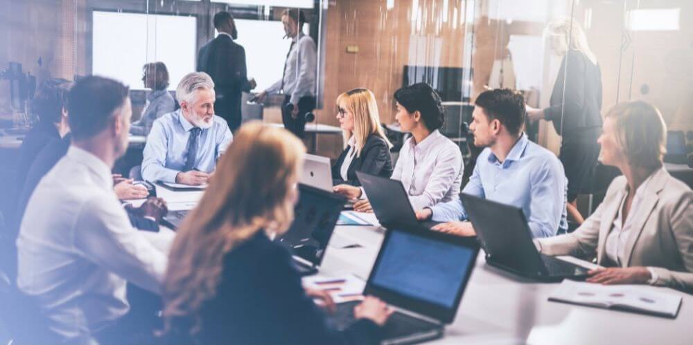 grupa osób uczestniczy w spotkaniu biznesowym w przeszklonej sali konferencyjnej