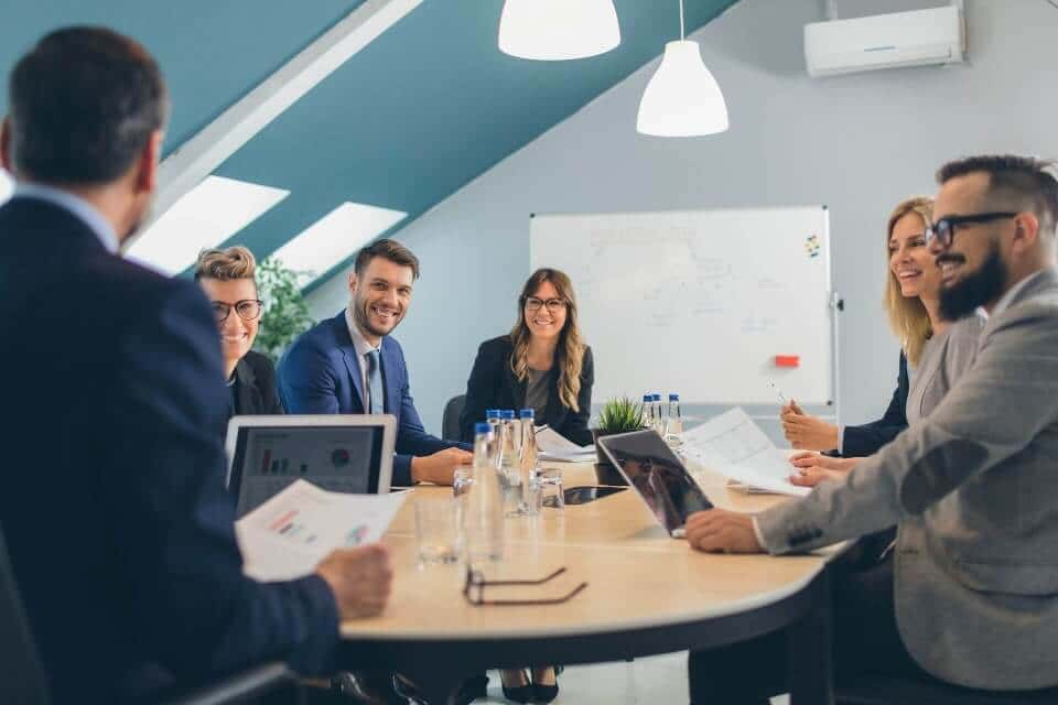 Zdjęcie przedstawia zespół projektowy omawiający wdrożenie IT